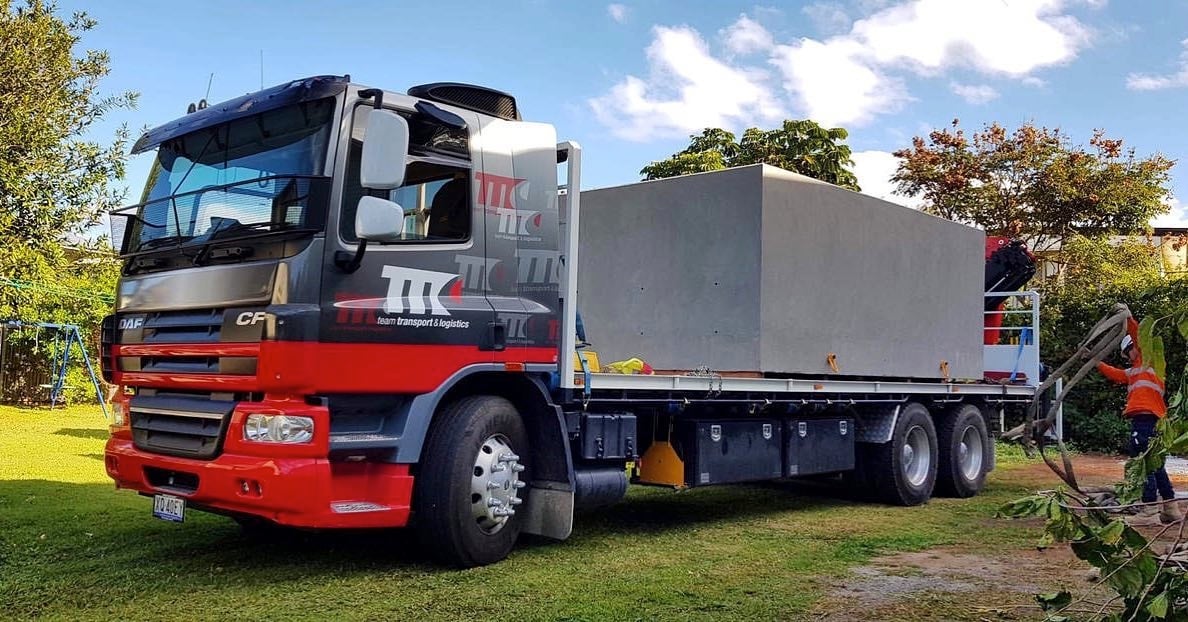 Flat bed truck with Plungie concrete pool on it.